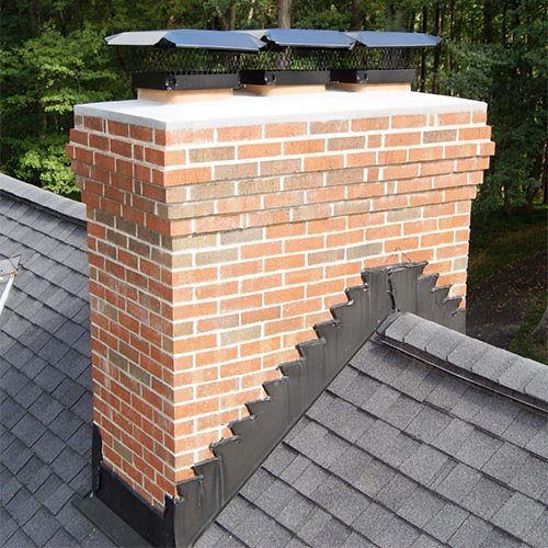 A brick chimney with three flue caps and new flashing
