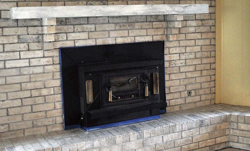 A brick fireplace with a black insert
