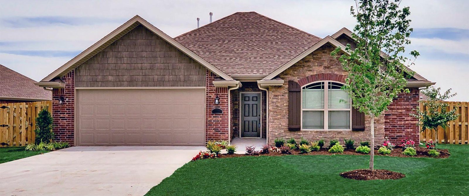 A brick house with a new brown shingle roof