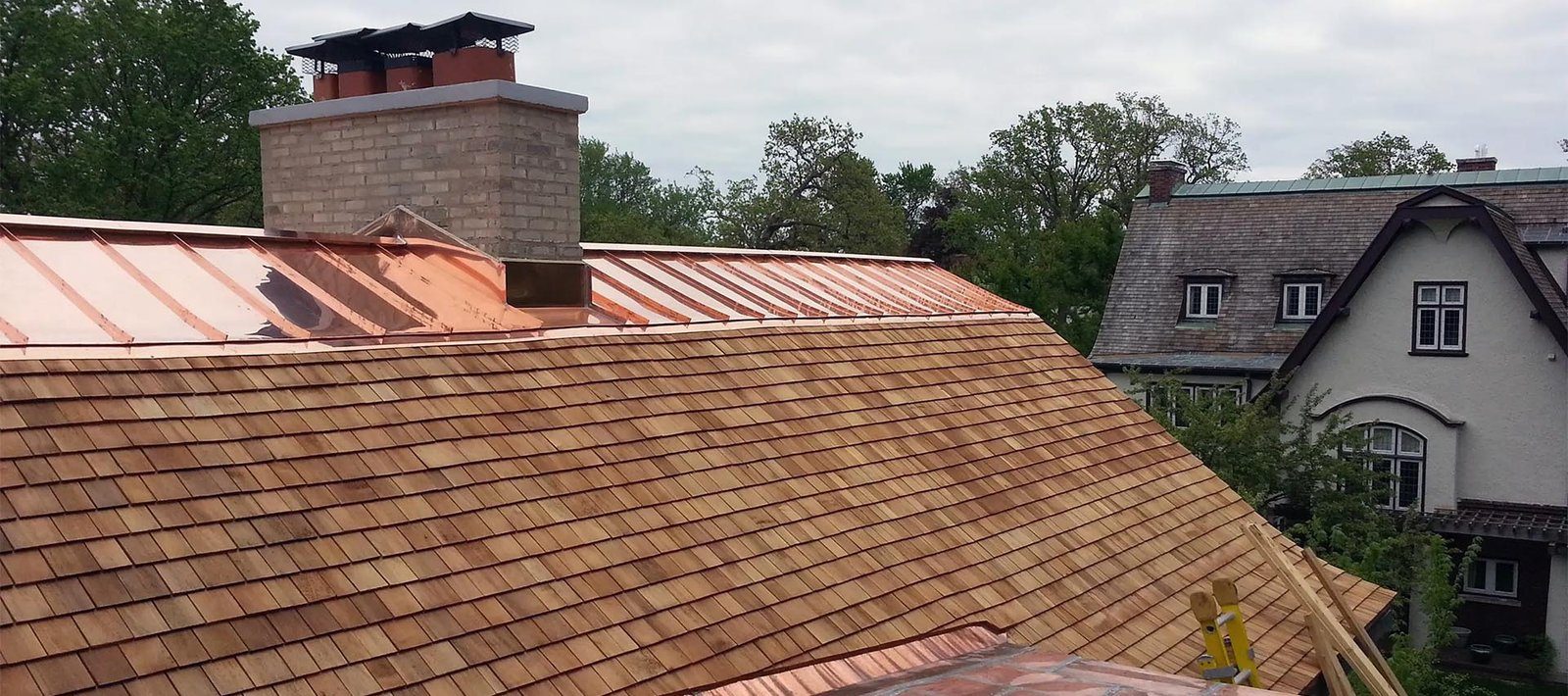 A cedar roof with a copper ridge and a stone chimney