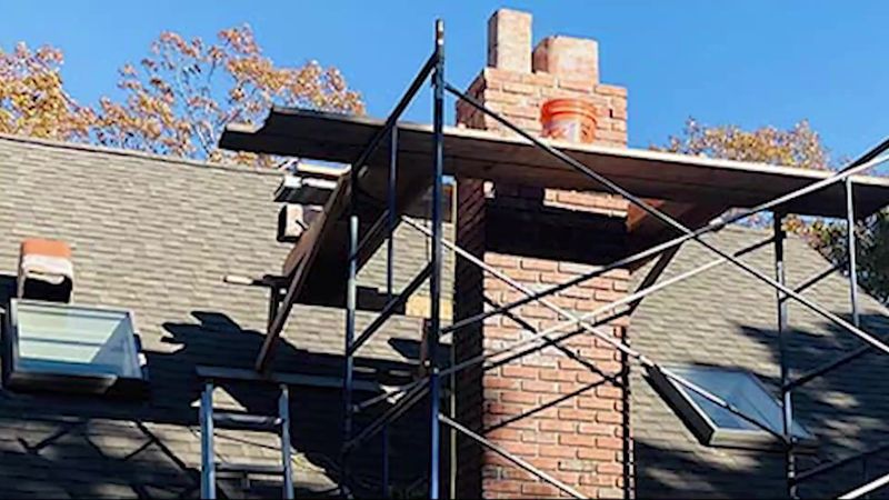Scaffolding set up around a brick chimney for a rebuild