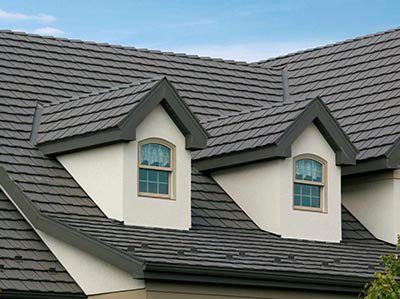 A dark flat-tile roof with two dormers