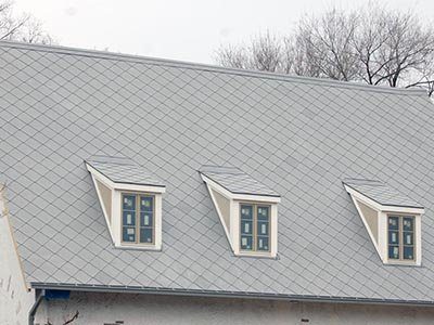 A pale grey diamond-pattern roof with three dormers