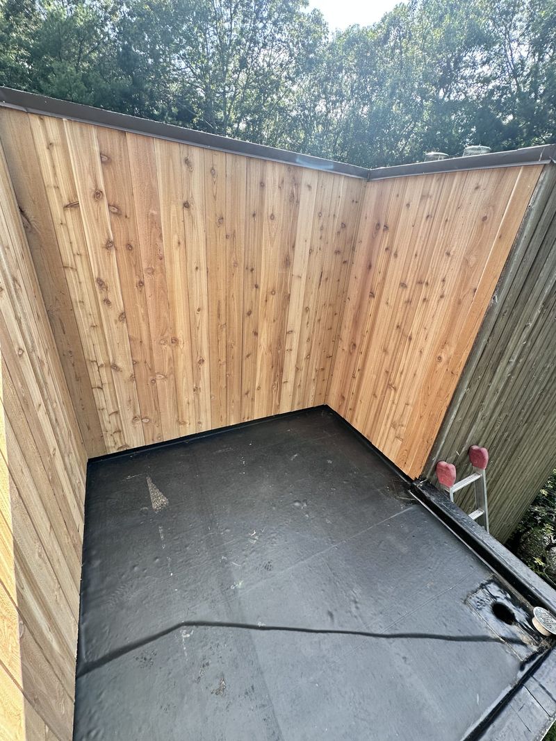 A small flat roof with a new membrane, enclosed by new cedar boards