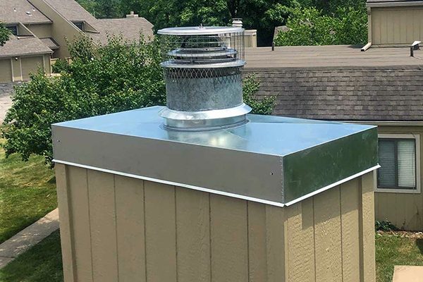A galvanized chase cover and cap on a sided chimney chase