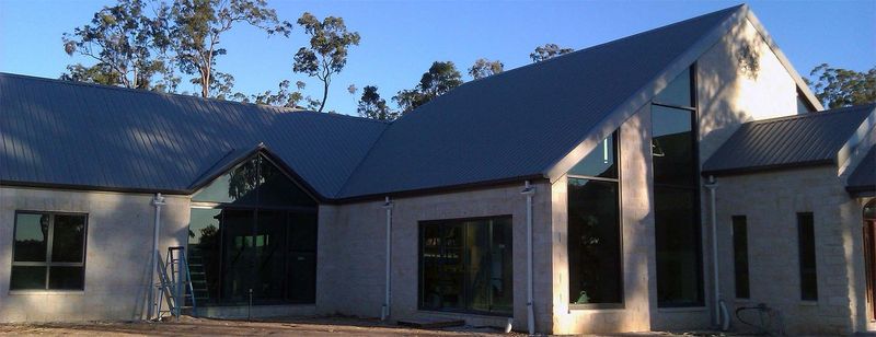 A large building with a new dark roof and tall gable windows
