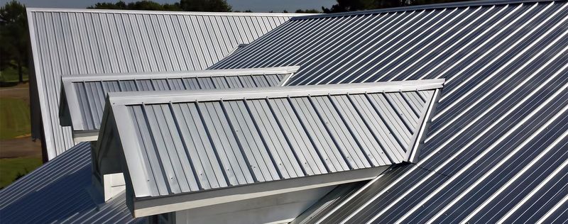 A grey standing seam metal roof with a dormer