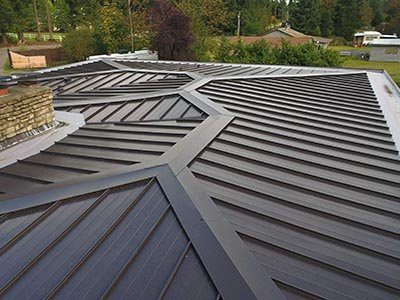 A dark metal roof with crisp hips and valleys