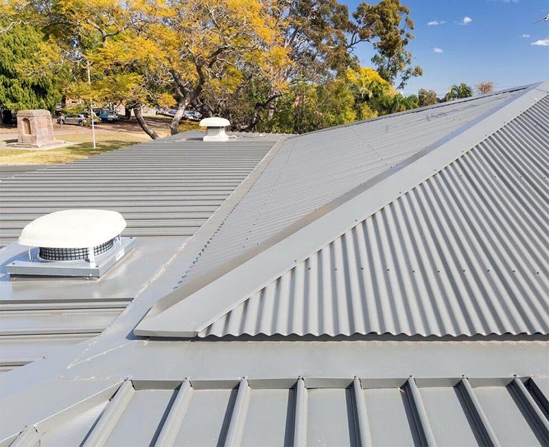 A grey metal roof with a roof vent