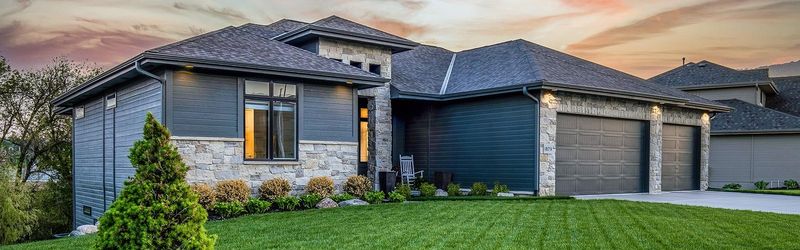 A modern house with a dark roof at dusk
