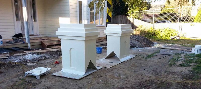 Two precast chimney tops on the ground at a job