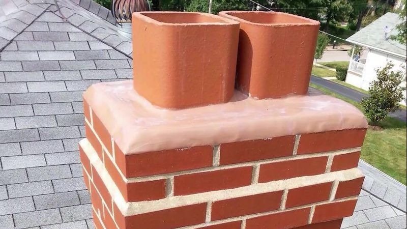 A rebuilt brick chimney with a new crown and two new clay flue tiles