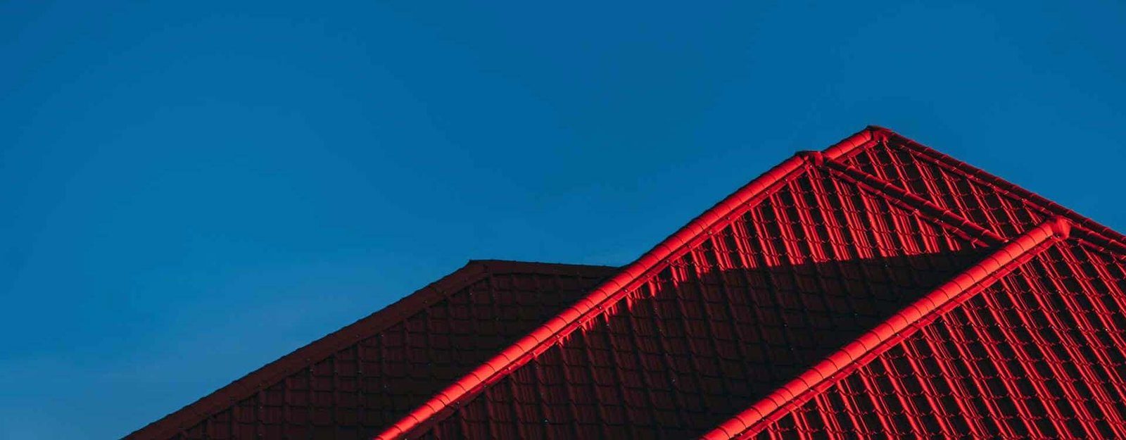 A red metal roof against a blue sky