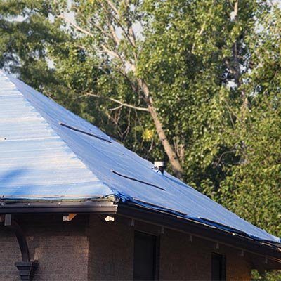 A blue emergency tarp on a roof