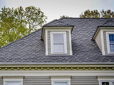 A grey shingle roof with two dormers