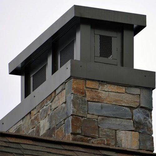 A stone chimney with a dark metal cap