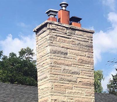 A stone chimney with three chimney pots