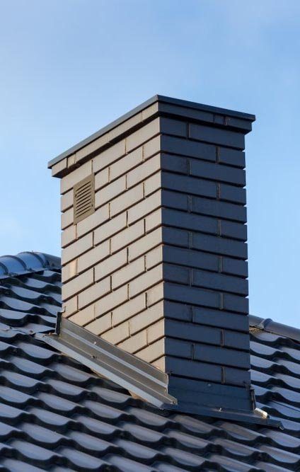A tall chimney on a tile roof